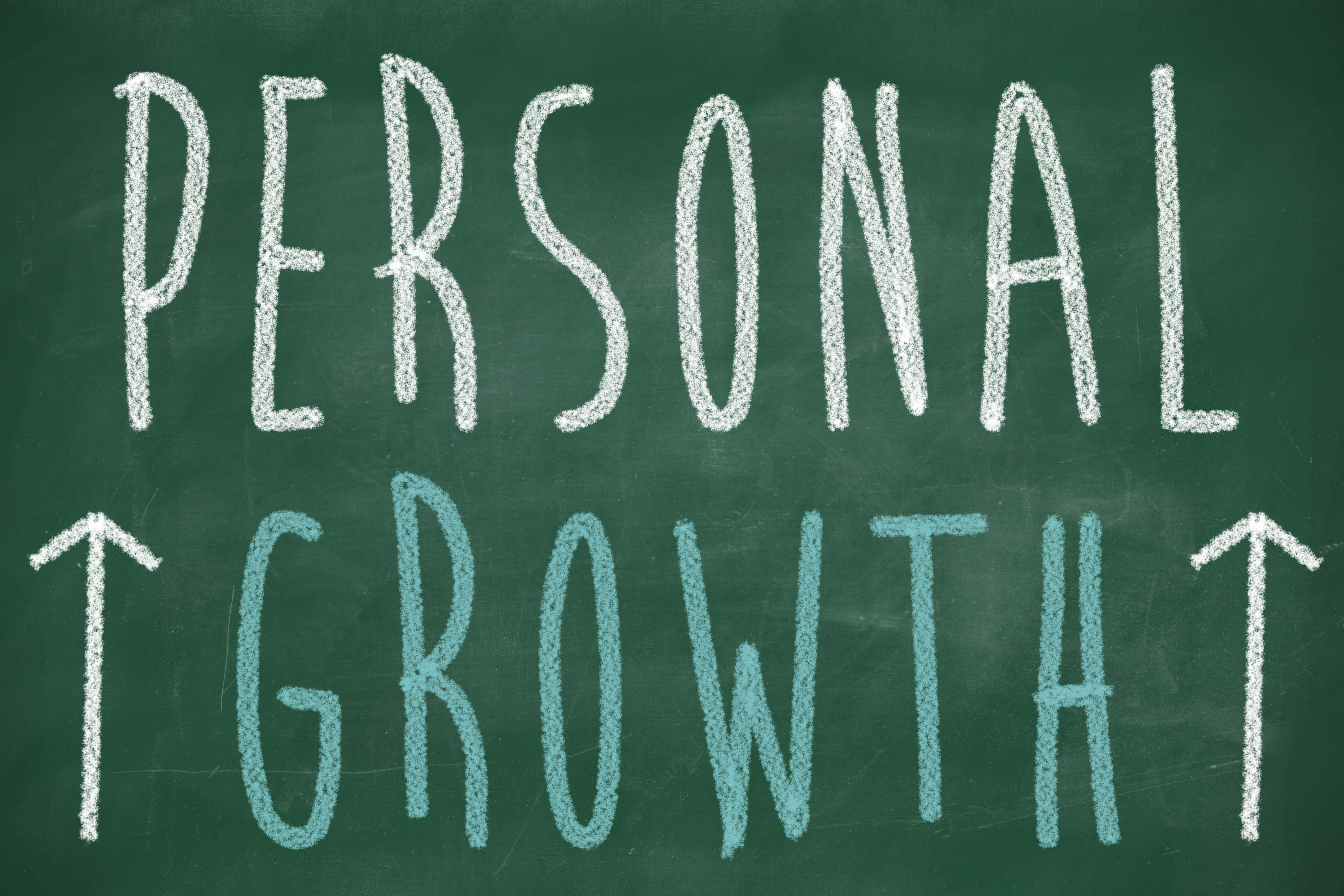 Personal growth phrase handwritten on the chalkboard with rising arrows